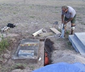 A national park ranger with equipment next to a gravesite.
