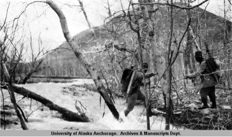 Historic photo of two researchers crossing river.