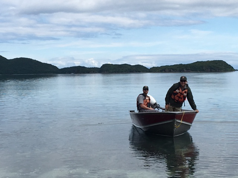 Two rangers approach on a small boat