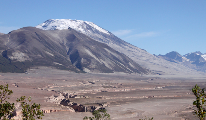 View of ash covered valley with surrounding volcanoes