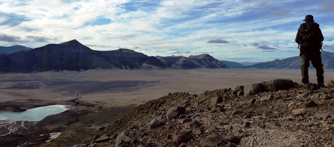A hiker admires the view of the Valley of Ten Thousand Smokes from the slopes of Mount Mageik.