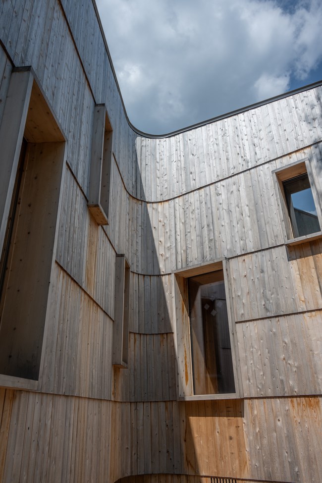 The inside corner of a contact station wall, curved with blue sky and clouds in the background.