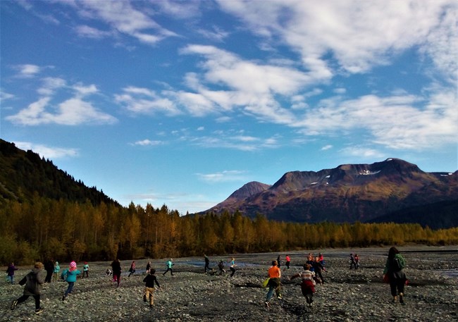 A group of students explore a rocky outwash plane in the Exit Glacier area