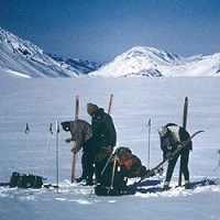 Four skiers from the 1968 crossing of the Harding Icefield prepare their gear.