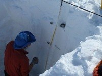 Researchers measuring snow depth and density.