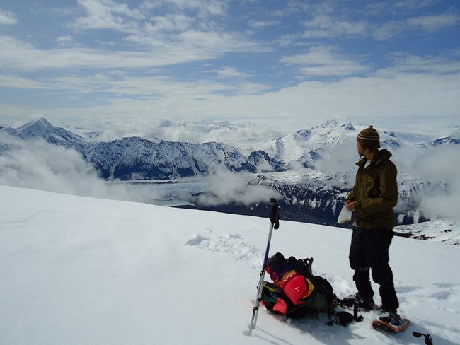 A mountaineer looks at view from mountaintop