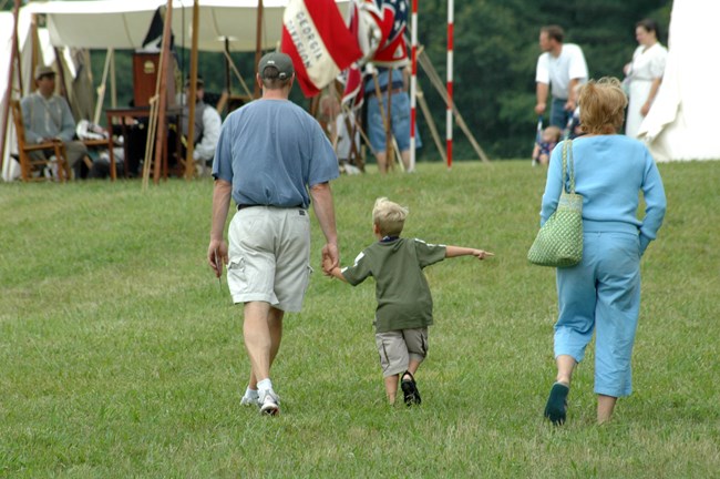 Two adults walk with a child between them