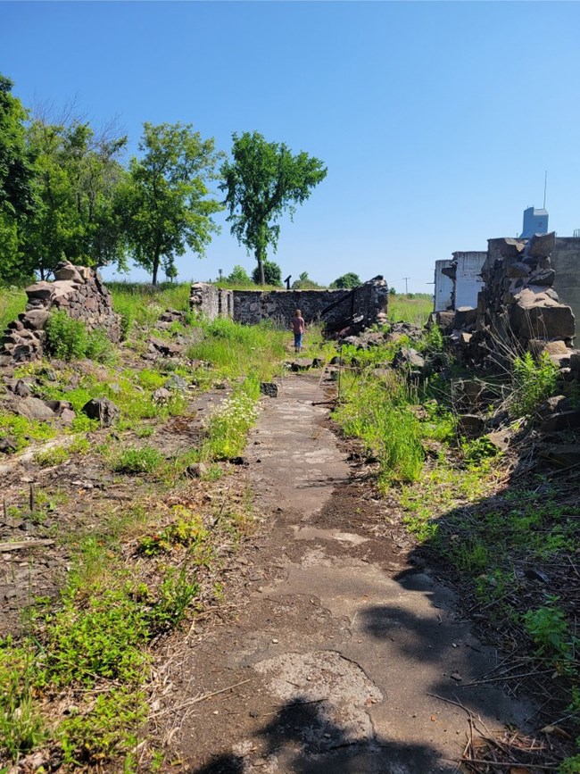 The foundation of a ruined building covered in green grass.