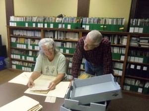 Two volunteers look through documents inside the History Center.