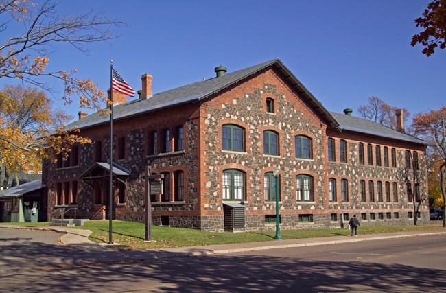 large brown brick building with stairs and ramp to front door