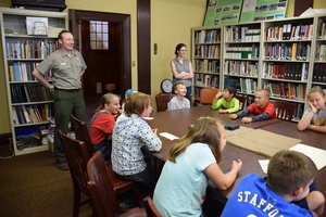 Seated students have a discussion about old photographs.