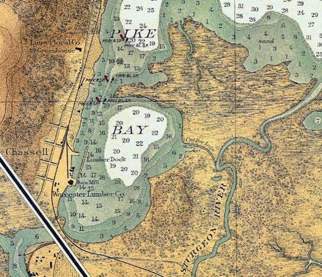 A cropped image of a 1912 nautical chart of the Keweenaw Peninsula. Pike Bay is centered in the image. The Sturgeon River outlet into Pike Bay with depth readings and the village of Chassell. The Worcester Lumber Co. is labeled.
