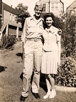 Historic Photo: Man and woman standing in a garden.