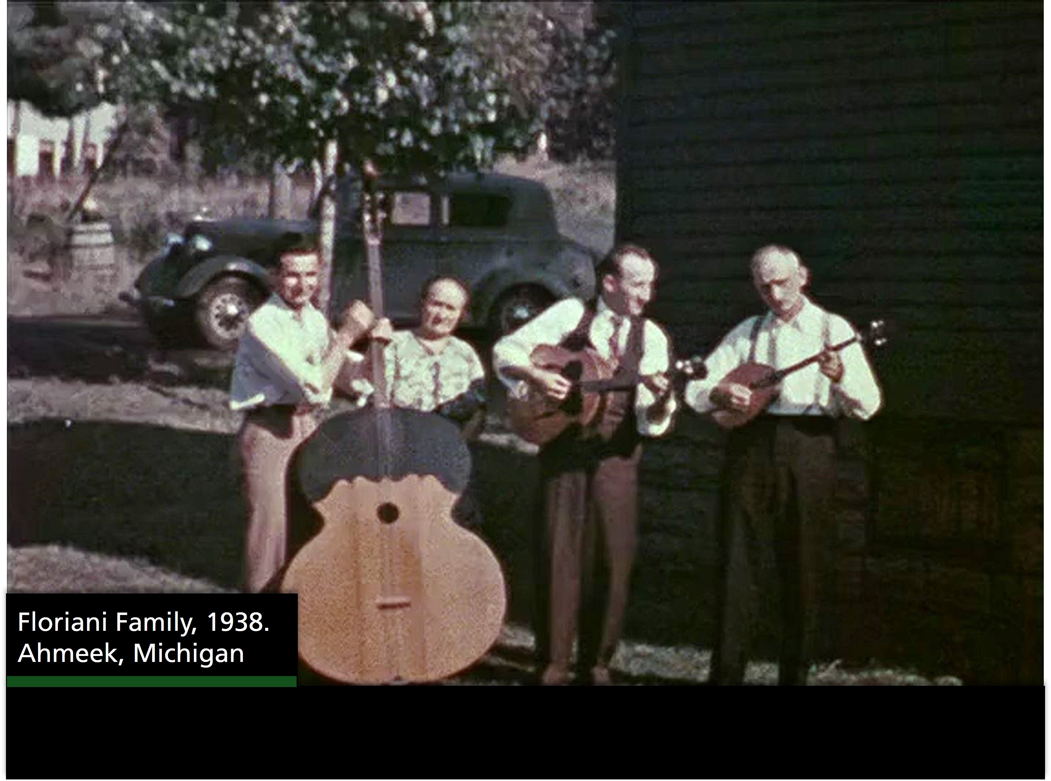 From left to right a man with a large bass instrument, a woman, a man with guitar and another man with another string instrument. A text box reads "Floriani Family, 1938. Ahmeek, Michigan