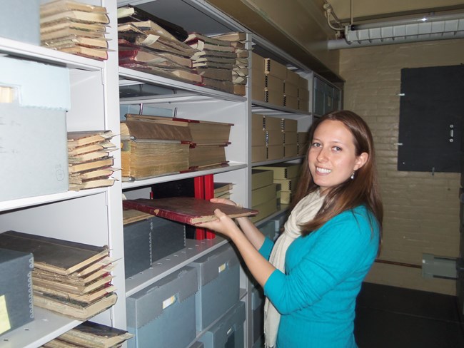 HAI processing archivist Annelise Doll is shown here with some of the recently processed Quincy Mining Company records at the Keweenaw NHP archives facility in Calumet.