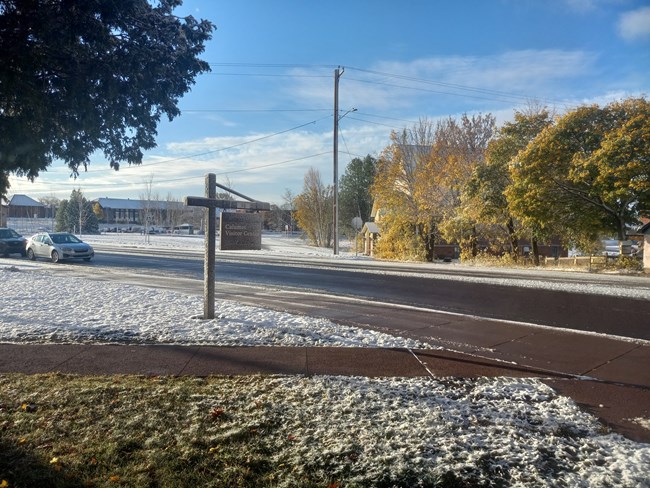 A dusting of snow covers the ground and buildings.