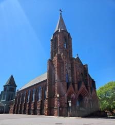 a sandstone brick church with bell tower