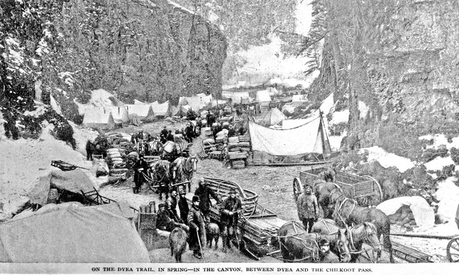 Stylized image of horses, sleds, tents, and people in a narrow, rocky canyon.