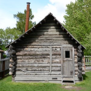 Log cabin with metal stovepipe.