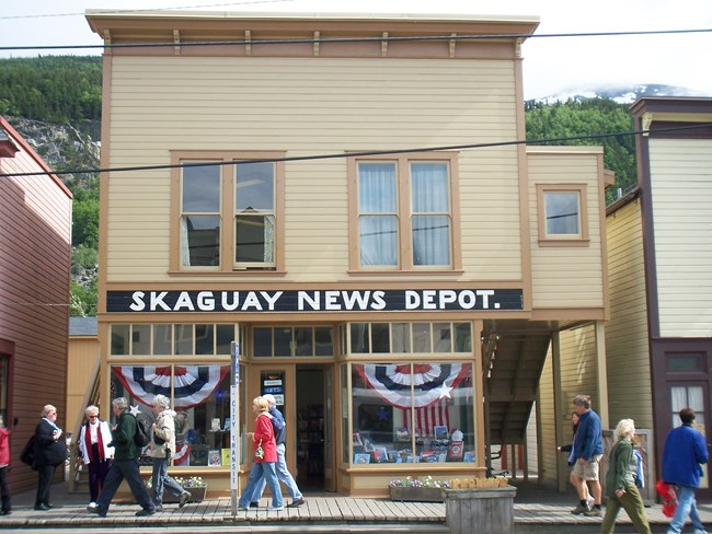 Two story Victorian style building with sign reading "Skaguay News Depot."