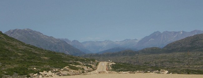 A dirt road in a valley edged by mountains