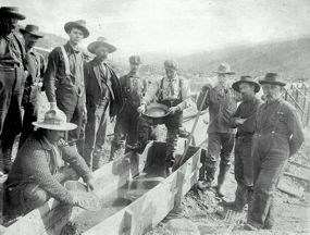 Historic image of men gathered around a sluice box