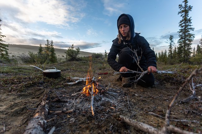 Visitors make campfire along the sand dunes