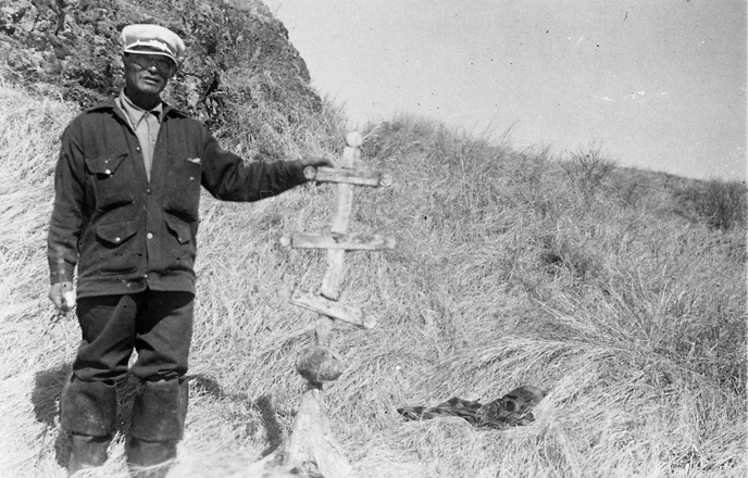 black and white image of an alaska native man standing in a field