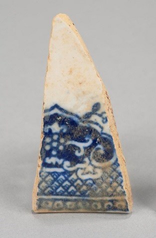 A blue and white piece of broken dinnerware