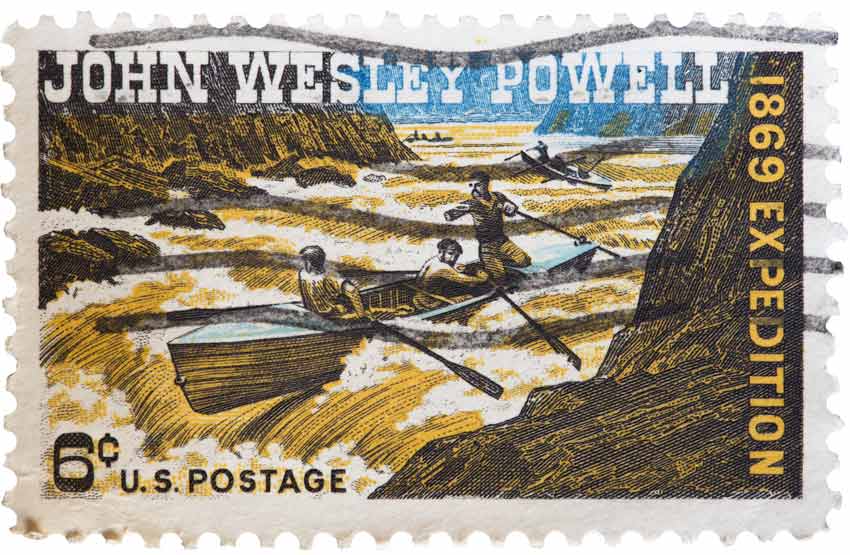 A postage stamp showing John Wesley Powell facing the rapids of a river.