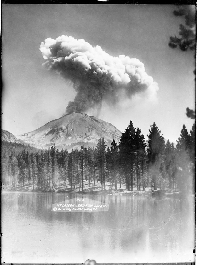 historic photograph of Lassen Peak erupting over Manzanita Lake