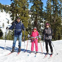 A family poses on cross-country skis