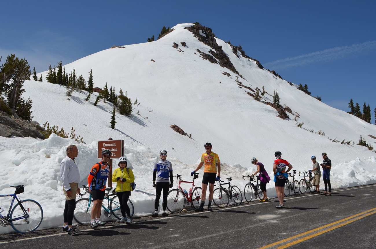 group of bicyclists posing by roadway with snow behind