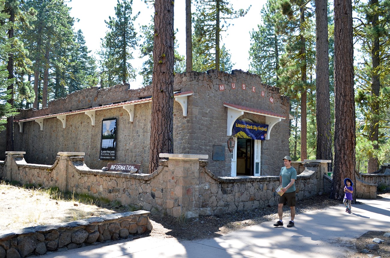 historic stonework building among tall pine trees