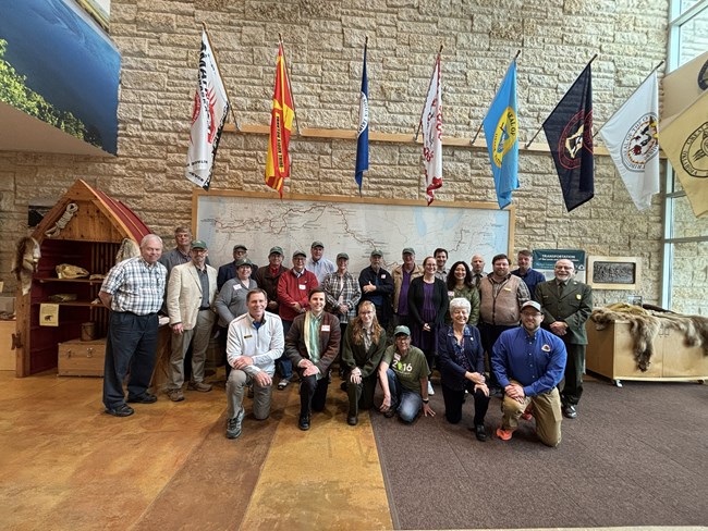 a large group of people pose in front of a map