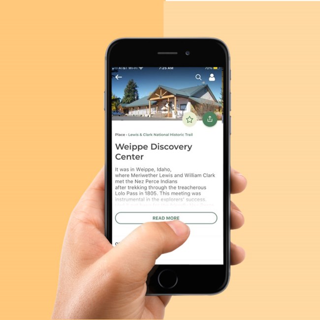 Hand holding phone. App highlights Weippe Discovery Center with information
