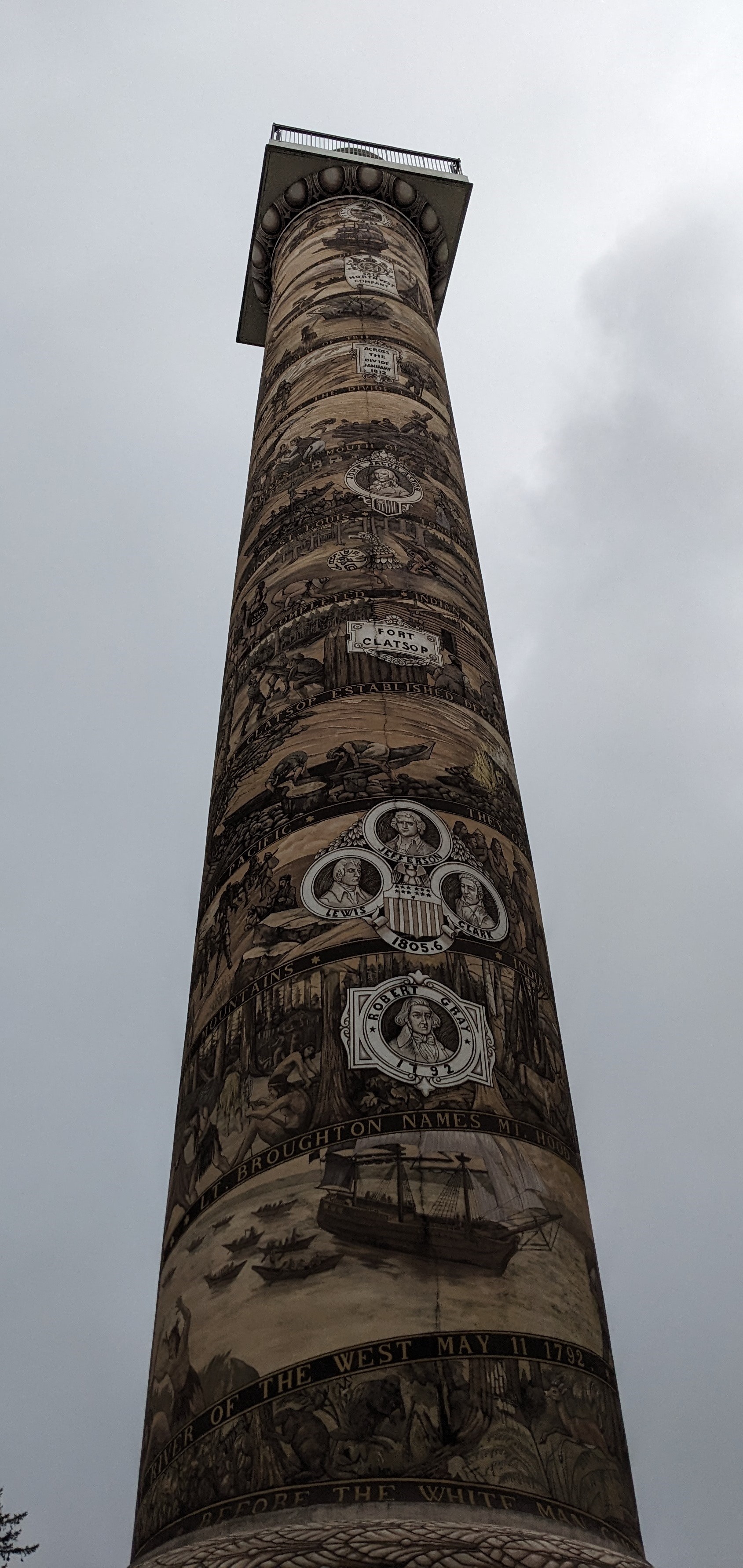 Looking up from the very bottom of the column to the very top. The column depicts the history of Astoria from pre-1800's to modern era.