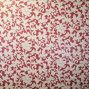 Red wallpaper with pattern of off-white trumpet-shaped leaves and plants