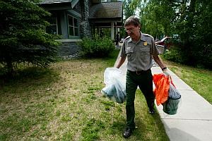 a park employee carries portable toilet cans in Denali National Park
