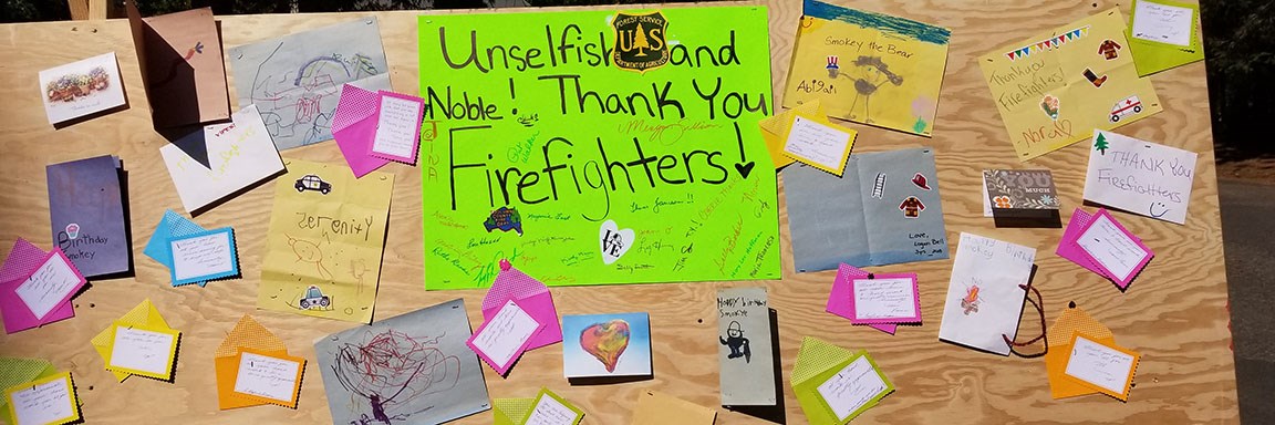 A fire camp board filled with posters and thank you cards.