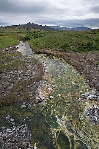 a river with algae flows through a rocky landscape