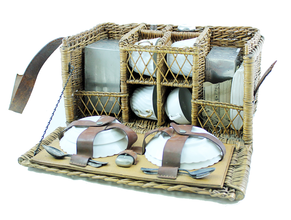 A wicker basket containing a portable tea set.