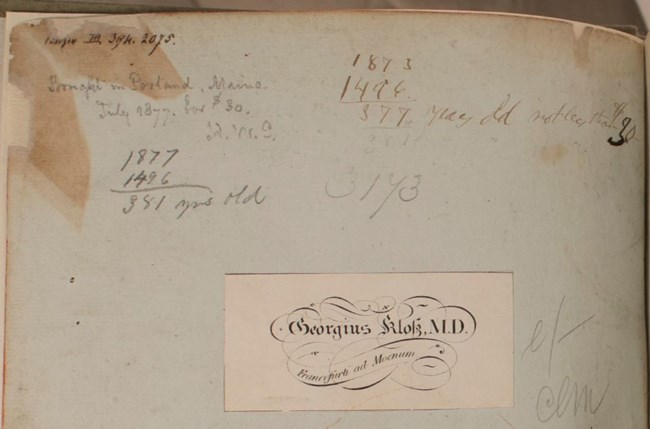Top of a book's flyleaf with bookplate and several handwritten inscriptions