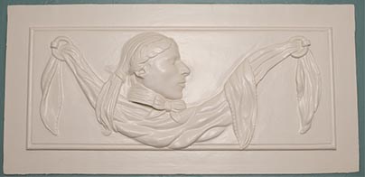 White-painted relief of man in profile with laurel wreath, bow at neck, and drapery across panel