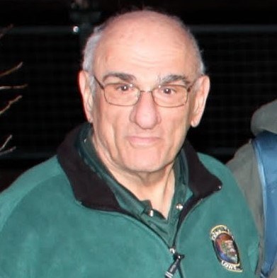 A square photo of a man. He is wearing a National Park Service volunteer shirt