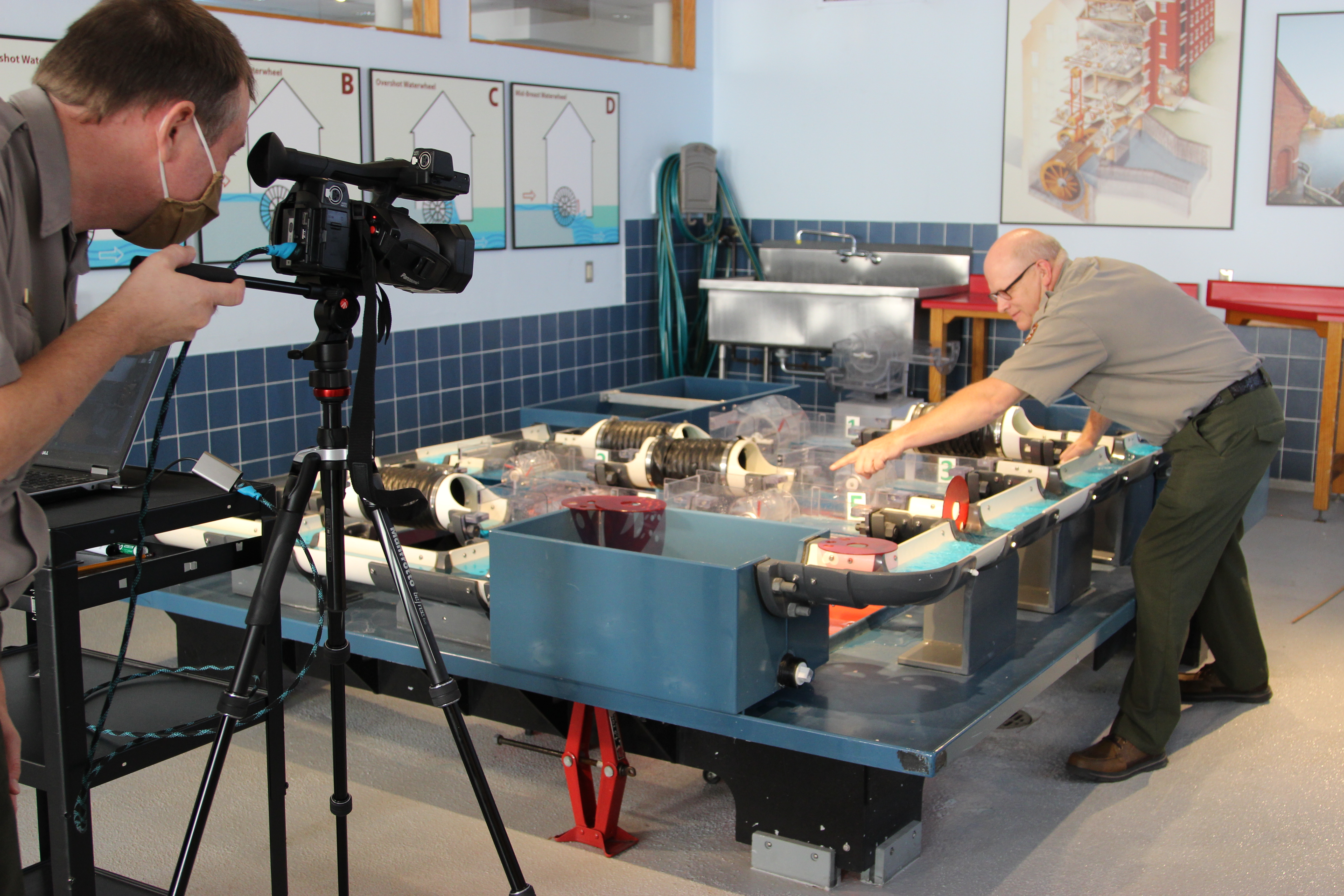 A park ranger teaches about water power using a large model of a canal system.