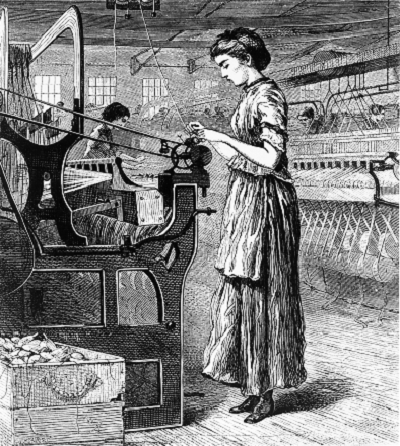 A weaver stands at a loom on a factory floor