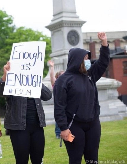 Demonstrators hold a Black Lives Matter sign in front of the Ladd and Whitney Monument in June 2020