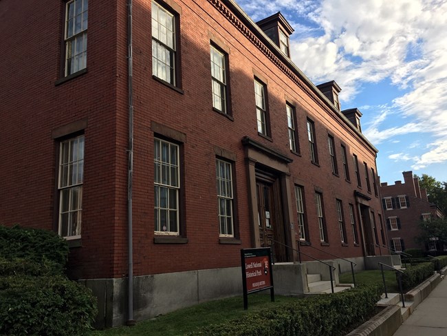 A modern day photograph of the Kirk Street Agents House, a three story red brick building with dormer windows emerging from the roof.