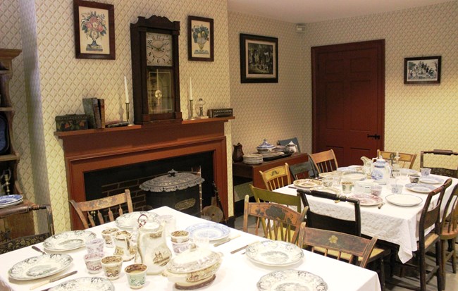 Historic dining room featuring tables with place settings.